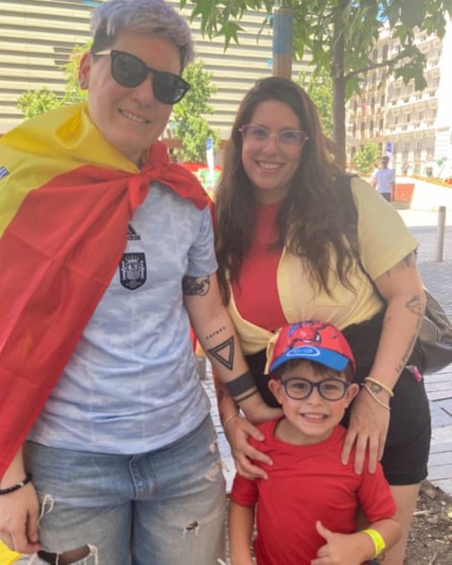 Laura Luengo (left, draped in a Spanish flag) with her wife, Tamara Rodríguez, and their son, álvaro